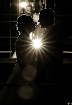 the silhouette of a bride and groom with a light shining on them